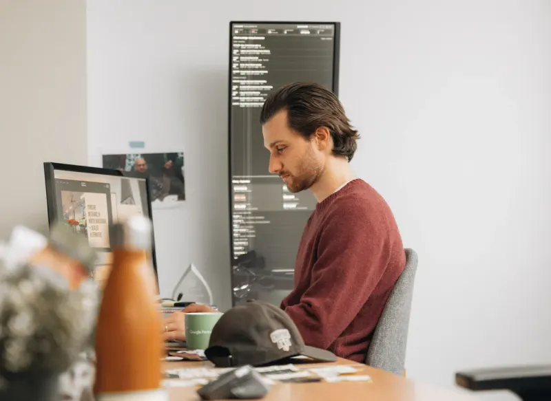 A Setsail Marketing specialist at his desk in front of two monitors