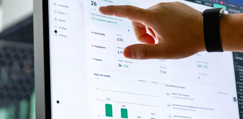 A hand pointing at a dashboard on a large screen