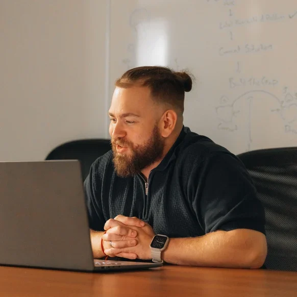 A Setsail SEO & Local Specialist at a meeting table with his laptop