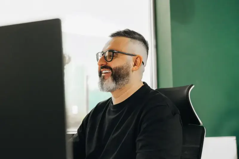 A smiling developer at his desk