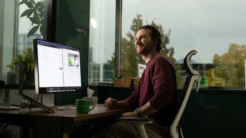 A Setsail strategist at his desk by the office window, a report open on screen.