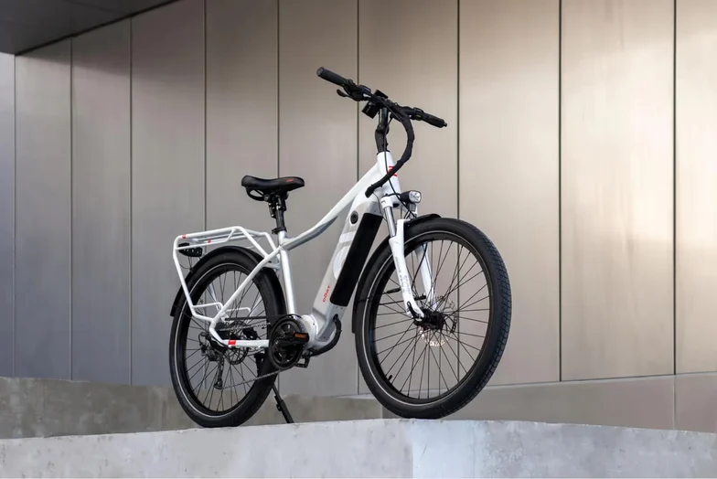 A DŌST e-bike parked against a grey wall