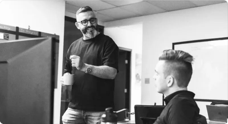Two Setsail colleagues at a desk in the studio, in black and white