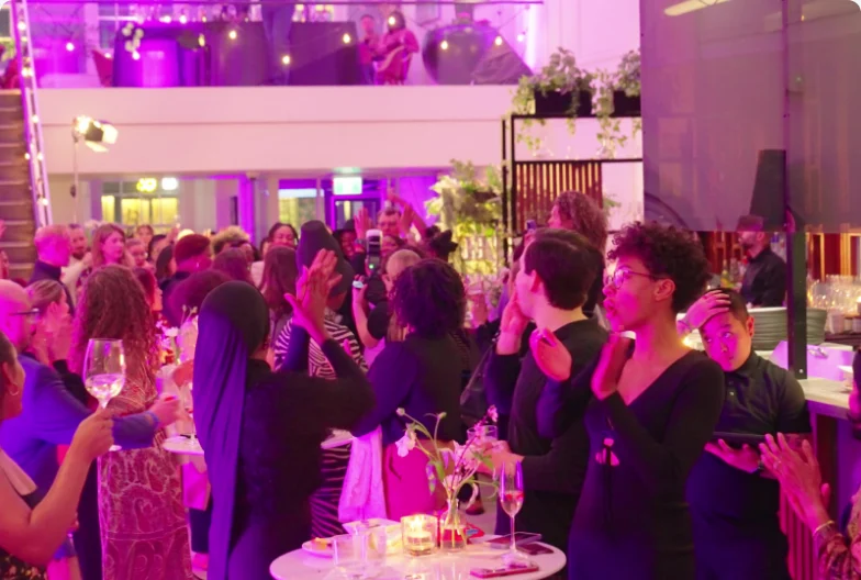 A crowd dancing under purple stage lights at the Champions Retreat evening party