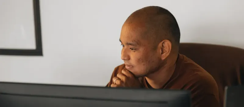 A Setsail designer studying his monitor, chin on his hands