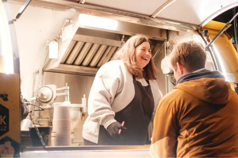 Two people talking at a food truck window, from Setsail’s photography for the City of Coquitlam