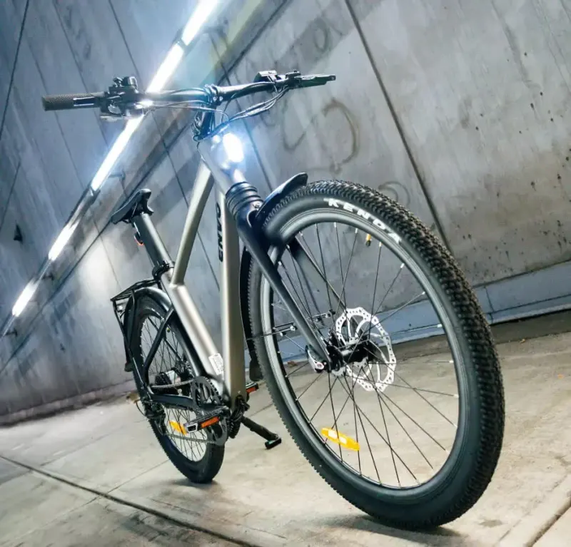 Low-angle night shot of an e-bike with its headlight on, parked in a concrete underpass