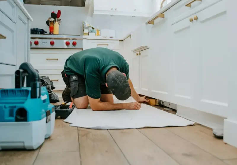 A Microworks technician fitting a kitchen cabinet base on a protected floor