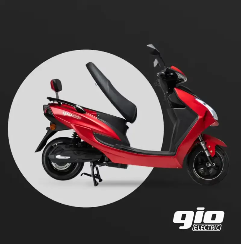Red GIO Electric scooter in side view with the seat raised, shown in a circle on a dark background
