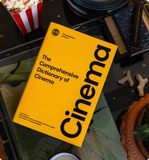 A yellow book cover reading “Cinema” on a table with popcorn