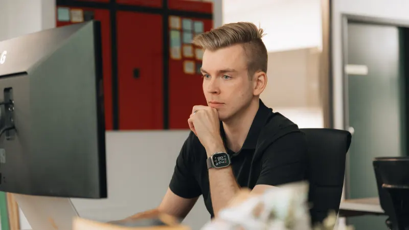 A Setsail strategist thinking over a site at his monitor, chin in hand.