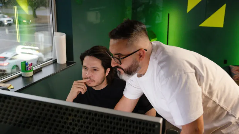 Two Setsail strategists working through a screen together, one leaning in to help.