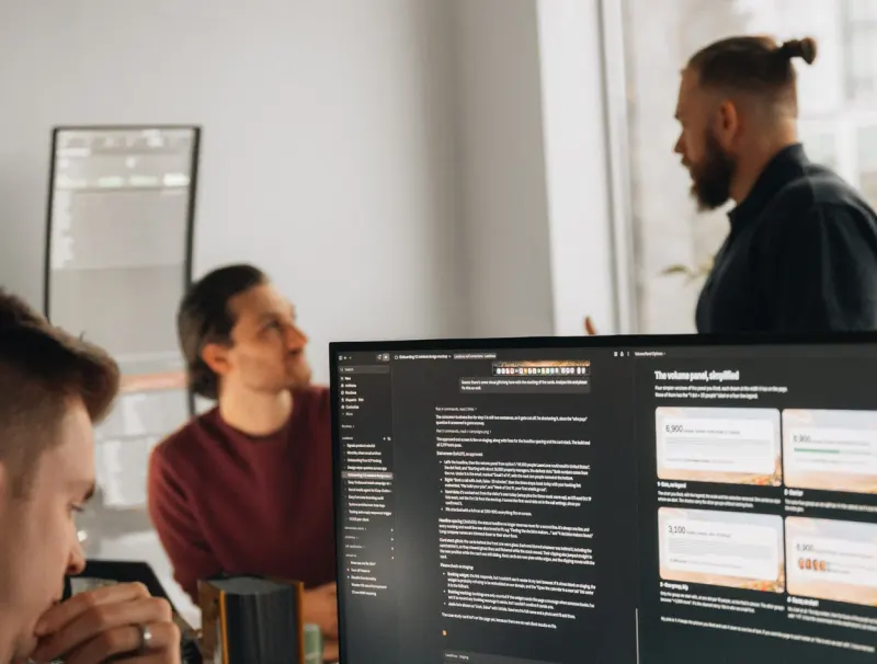 Three Setsail Marketing team members talking through a plan on a large monitor