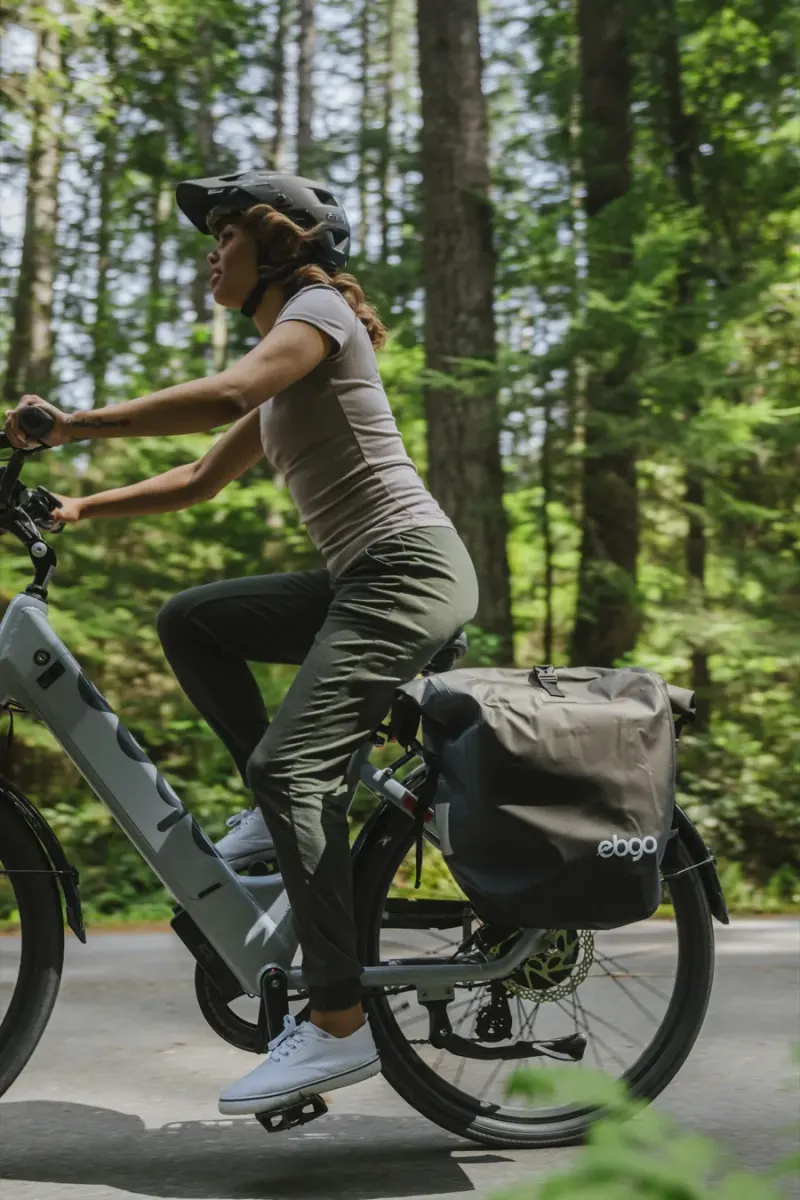 A rider on an EBGO e-bike with a pannier, seen close from the side