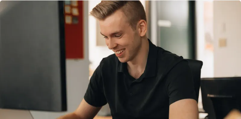 A Setsail team member smiling at his monitor