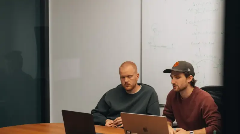 Two Setsail Marketing team members working through a plan at their laptops