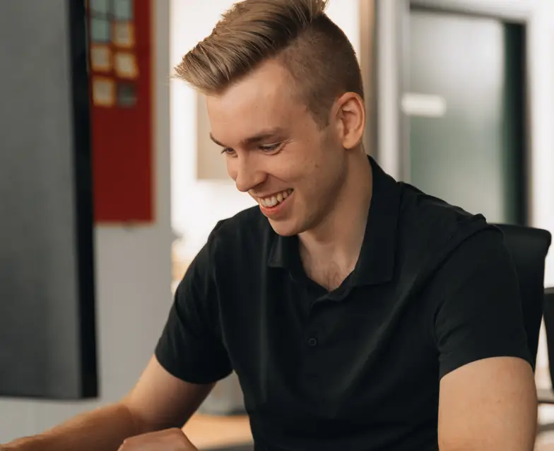 A Setsail team member smiling at his desk