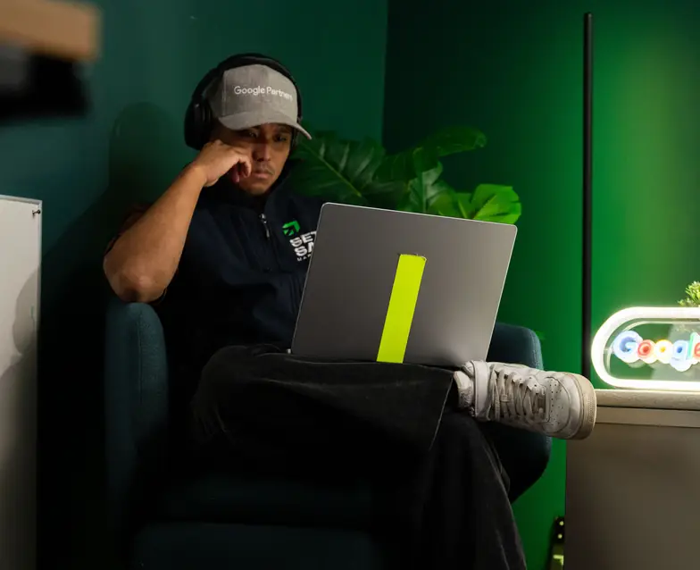 A Setsail team member on a call with a laptop in a green-lit room