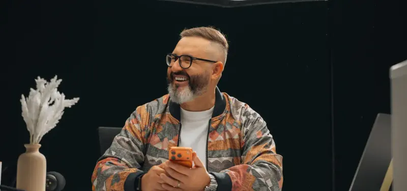 A Setsail designer smiling at his phone at his desk
