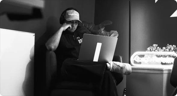 A Setsail team member working on a laptop in a lounge chair, in black and white