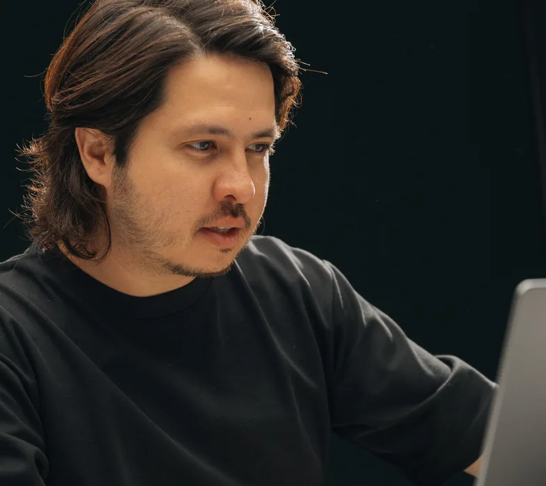 A team member reviewing work on his laptop