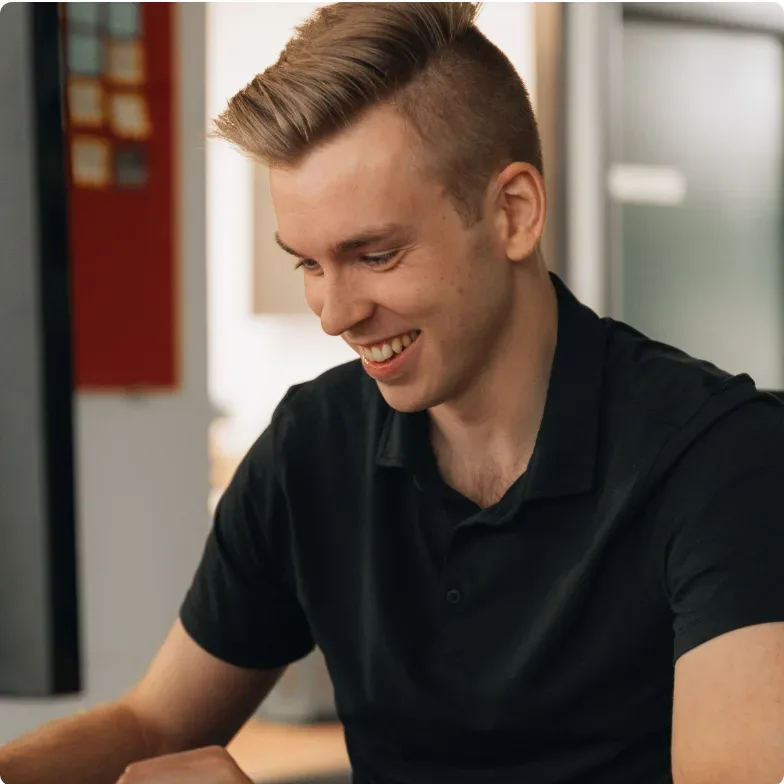 A Setsail web designer smiling at his screen