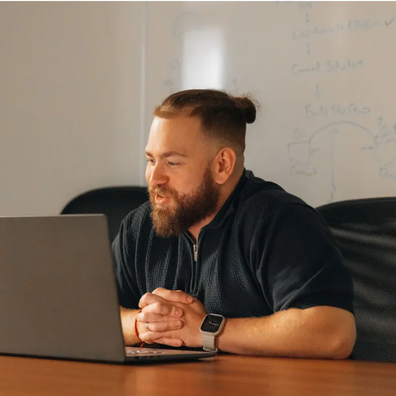 A Setsail account lead at a meeting table with his laptop