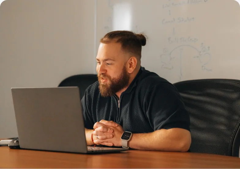 A Setsail Marketing strategist at his laptop in front of a whiteboard