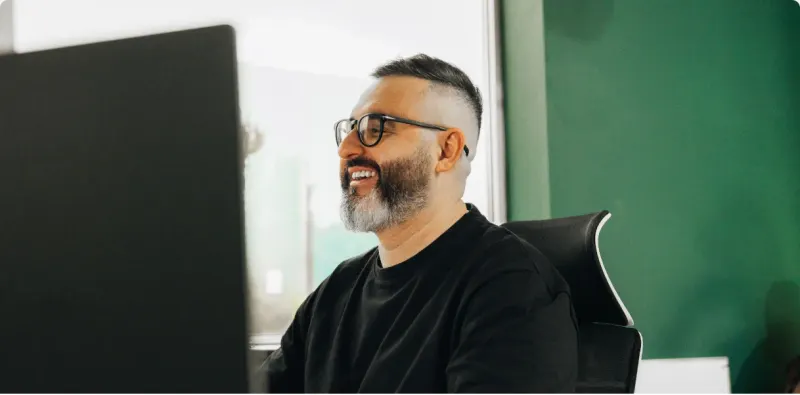 A sample sending health card: inbox placement after warmup, authentication set up, dedicated sending domains, and the primary domain never sending, over a Setsail team member smiling at a monitor
