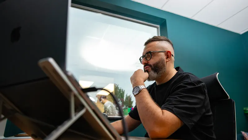 A Setsail strategist thinking at his desk by the office window.