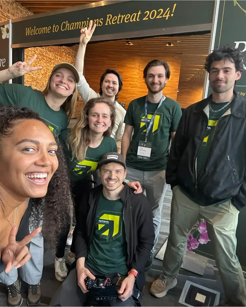 Setsail Marketing team in green branded shirts posing under a Welcome to Champions Retreat 2024 sign