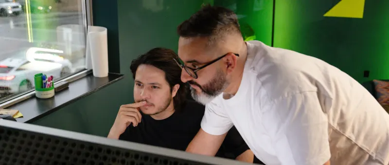 Two Setsail colleagues looking at a monitor together in the Vancouver office