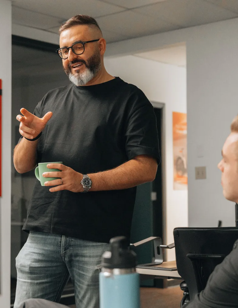 A team member talking through an idea, coffee in hand