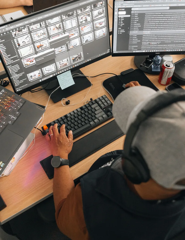 An editor at a two-screen workstation, headphones on