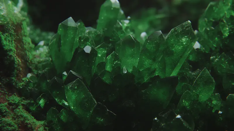 A close-up of a cluster of green crystals with sharp facets.