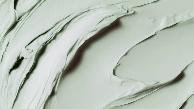 A close-up of smooth mint green plaster swept into glossy swirls.